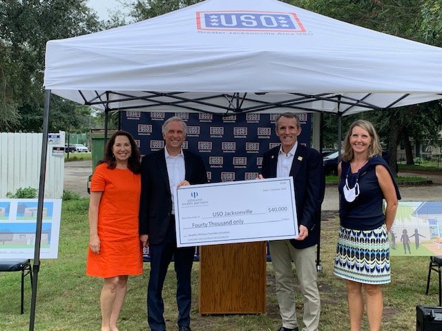 Glenn and Lisa Ullmann, left, present a check for $40,000 to USO of Greater Jacksonville Executive Director Michael O’Brien. At right is Francie Peters, marketing and communications manager for Ullmann Wealth Partners.
